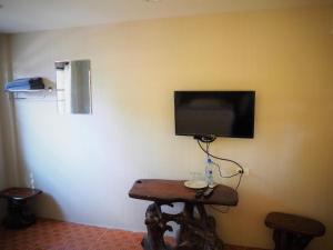 カンチャナブリにあるT & T Hostel Kanchanaburiの壁に薄型テレビが取り付けられた部屋