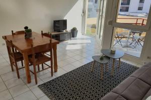 a living room with a table and a couch at Appartement plage de Trestraou in Perros-Guirec
