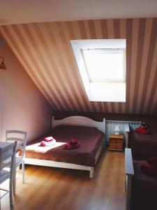 a attic bedroom with a bed and a window at Guesthouse Mõisa Ait in Võru