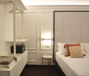 a white bedroom with a bed and a table at PALAZZO DELLE SIRENE Deluxe Apartment & Boutique Rooms in Levanto