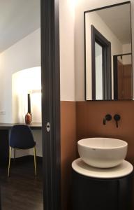 een badkamer met een witte wastafel en een spiegel bij PALAZZO DELLE SIRENE Deluxe Apartment & Boutique Rooms in Levanto