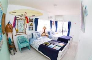 a bedroom with two beds and a surfboard on the wall at Splash Guest House in Katsuura