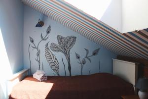 a bedroom with a bed with a flower mural on the wall at Guesthouse Mõisa Ait in Võru
