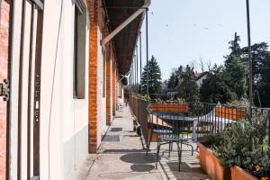 eine Terrasse mit Stühlen und einem Tisch an der Seite eines Gebäudes in der Unterkunft Azienda Agricola La Botanica in Lentate sul Seveso