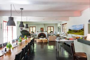 a dining room with a long table and a fireplace at Waldhotel am Nürburgring in Baar