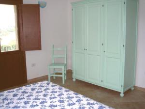 1 dormitorio con 1 cama y 1 silla en Residence Baia Santa Reparata, en Santa Teresa Gallura