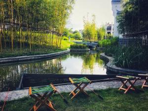 two chairs and a table next to a river at Banyan Tree Yangshuo in Yangshuo