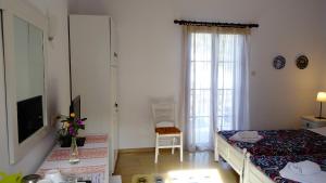 1 dormitorio con 1 cama y TV en una habitación en Lykomides en Skyros