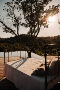 ein Schlafzimmer mit einem Bett auf einer Terrasse mit einem Baum in der Unterkunft The ONE - Country House in Grândola