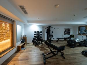 a gym with several treadmills and weights in a room at Hotel Ambiez in Andalo
