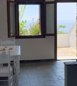 a room with a table and a view of the ocean at En Plo in Agios Romanos