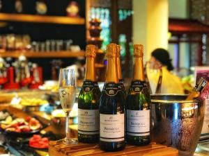 three bottles of wine on a table with a glass at Banyan Tree Yangshuo in Yangshuo