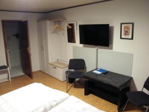 GörgeshausenにあるHotel Jägerstubeのベッド、デスク、テレビが備わる客室です。