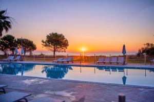 une piscine avec vue sur le coucher du soleil en arrière-plan dans l'établissement Casa e Natura, à Moriani-Plage