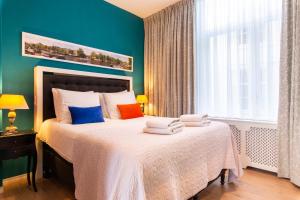 阿姆斯特丹鲜花住宿加早餐旅馆的卧室里有一张床,上面放着彩色枕头