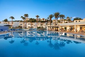 a large swimming pool in front of a resort at TRH Tirant Playa in Fornells