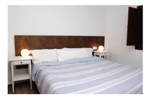a bedroom with a large bed with two night stands at Apartmentos Nort in Portinatx