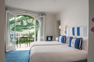 a hotel room with two beds and a balcony at J.K. Place Capri in Capri