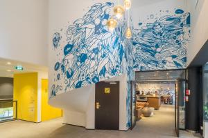 a lobby with a blue and white mural on the wall at Hostel Le Hüb Grenoble in Grenoble