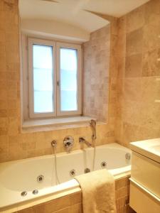 baño con bañera y ventana en Apartments Spittelberg Gardegasse en Viena