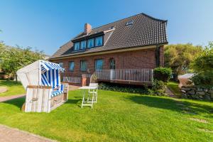 a house with two chairs and a gazebo in the yard at Ferienanlage am Trift in Westerland