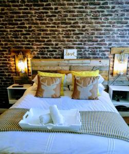 a large white bed with a brick wall at Boutique Coastal appt nr Edinburgh in Saint Davids