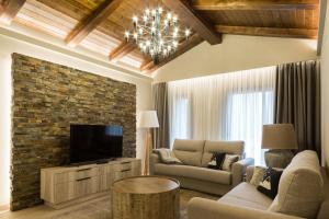 ein Wohnzimmer mit einem Sofa, einem TV und einem Kamin in der Unterkunft Hotel Montarto in Baqueira-Beret