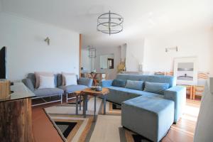 a living room with a blue couch and a table at Ocean House - First Line of Cabedelo Beach in Viana do Castelo