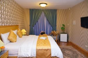 Un dormitorio con una cama grande y un televisor. en شقق منصور بلازا للشقق المخدومة, en Dammam 37 fotos más