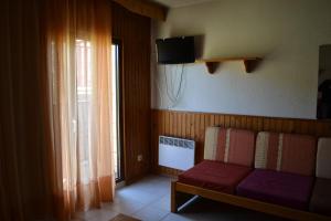 a living room with a couch and a tv at Apartamentos Frontera Blanca Nievesol in Pas de la Casa