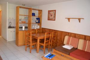 a kitchen and dining room with a table and chairs at Apartamentos Frontera Blanca Nievesol in Pas de la Casa