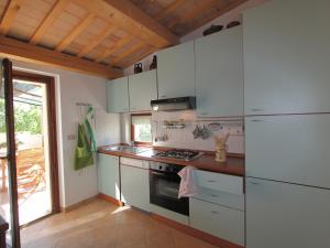 cocina con armarios blancos y fogones en Belvilla by OYO Casale le Querce, en Cossignano