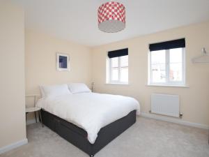 a bedroom with a large white bed and two windows at Modern 3BR Townhouse w/ Views of Oxford + Parking in Oxford