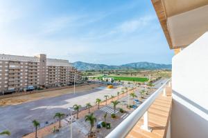 een balkon met uitzicht op een straat met palmbomen en gebouwen bij Vacaciones Oromarina Azahar in Oropesa del Mar