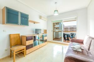 a living room with a couch and a tv at Vacaciones Oromarina Azahar in Oropesa del Mar