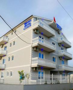 - un grand bâtiment avec des balcons sur le côté dans l'établissement Doci Seven Hotel, à Velipojë