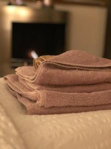une pile de serviettes assises au-dessus d'un lit dans l'établissement Chalet Aigle, à Crans-Montana