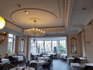 a dining room with tables and chairs and a chandelier at Fletcher Hotel-Restaurant de Dikke van Dale in Sluis