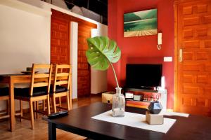 a living room with a table and a tv at Ático dúplex en Centro Histórico Toledo in Toledo