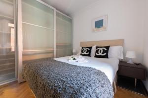 a bedroom with a large bed with black and white pillows at Apartamentos Day Madrid BALLESTA Centro Gran Via Sol Malasaña in Madrid