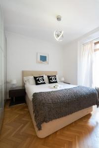 a bedroom with a large bed with black and white pillows at Apartamentos Day Madrid BALLESTA Centro Gran Via Sol Malasaña in Madrid