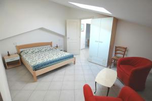 een slaapkamer met een bed en een rode stoel bij I Pungenti in Castiglioncello