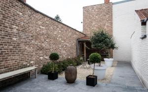 a courtyard with potted plants and a brick building at Maison de la Paix in Poperinge