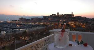 a bottle of champagne on a balcony with a view of a city at Hotel Splendid in Cannes