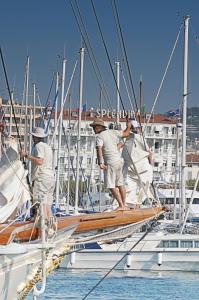 two men standing on a sail boat in the water at Hotel Splendid in Cannes