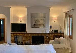 sala de estar con chimenea y TV en Casa Coromines, en Alcudia