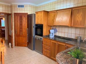 a kitchen with wooden cabinets and stainless steel appliances at Casa Coromines in Alcudia