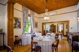 Roosenwijn Guesthouse في ستيلينبوش: غرفة طعام بها طاولات وكراسي وثريا
