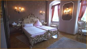 a bedroom with an ornate bed in a room at Schloss Sennfeld - Schloss Akademie & Eventlocation - in Adelsheim