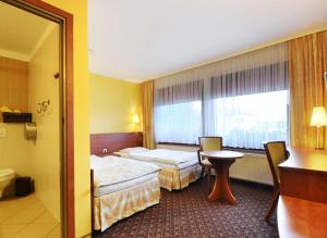 Postel nebo postele na pokoji v ubytování Hotel Astra Tajemniczy Ogród